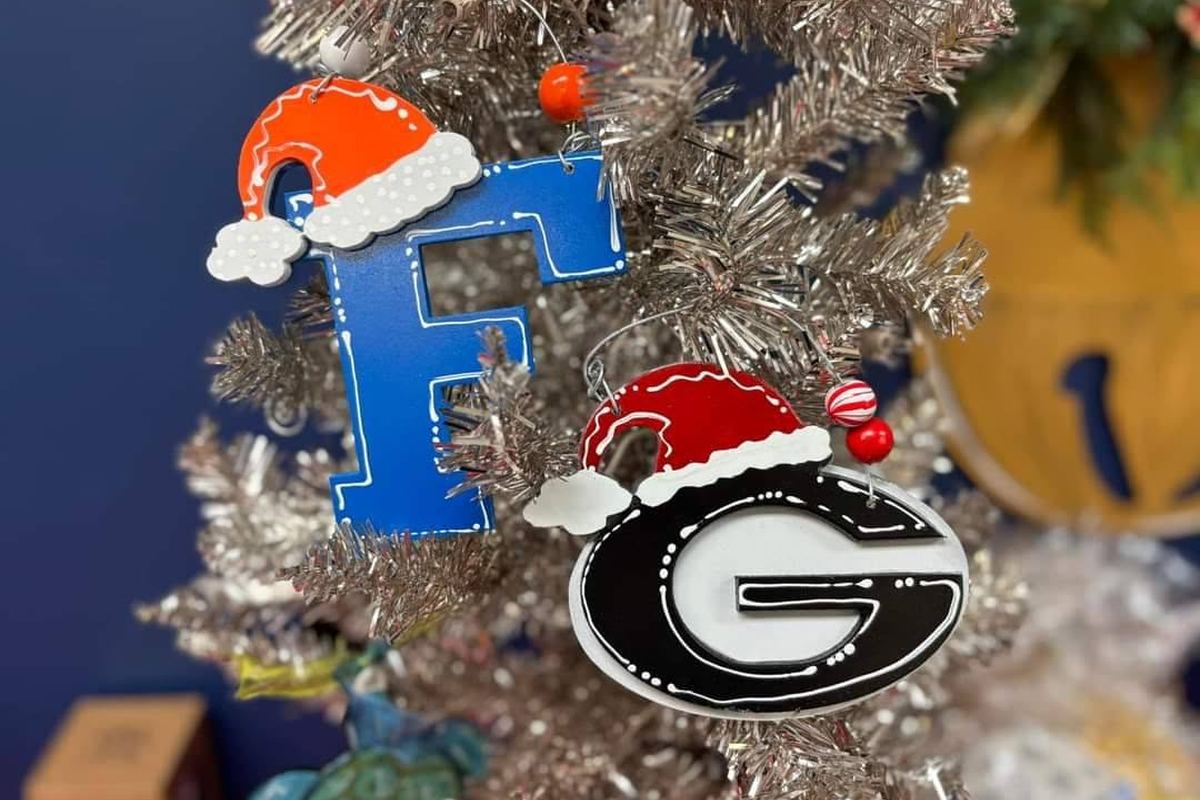 Hand-painted wooden game-day ornaments with Santa hats hanging on a silver tree